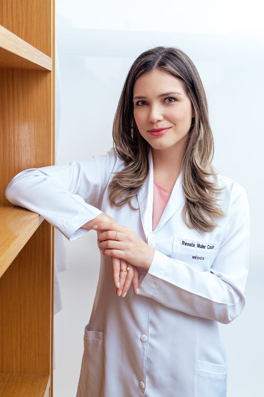 Dra. Renata Müller Couto, cardiologista, de jaleco branco no consultório em São Paulo